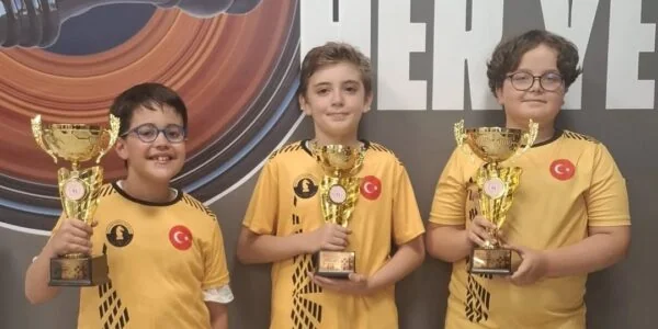 Sarı formalarıyla kupalarını tutan kulüp sporcuları